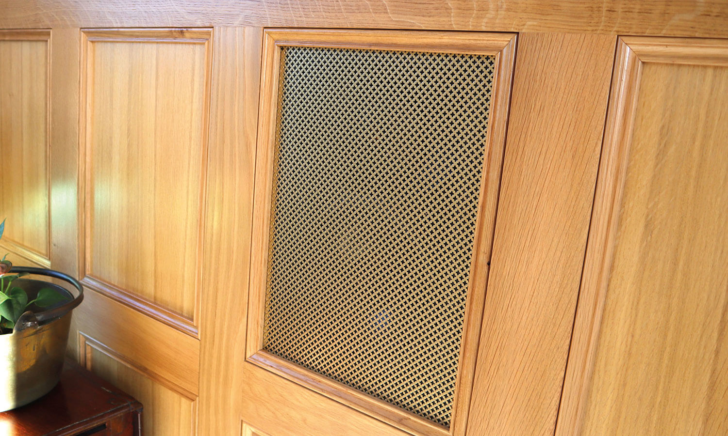 In wall speakers built into oak panelling with wooden grilles