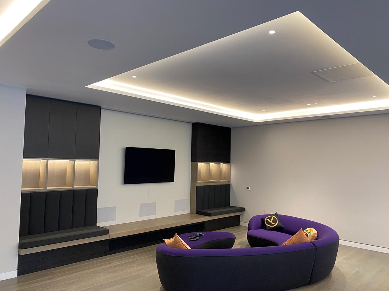 Games room with media wall with TV purple sofa