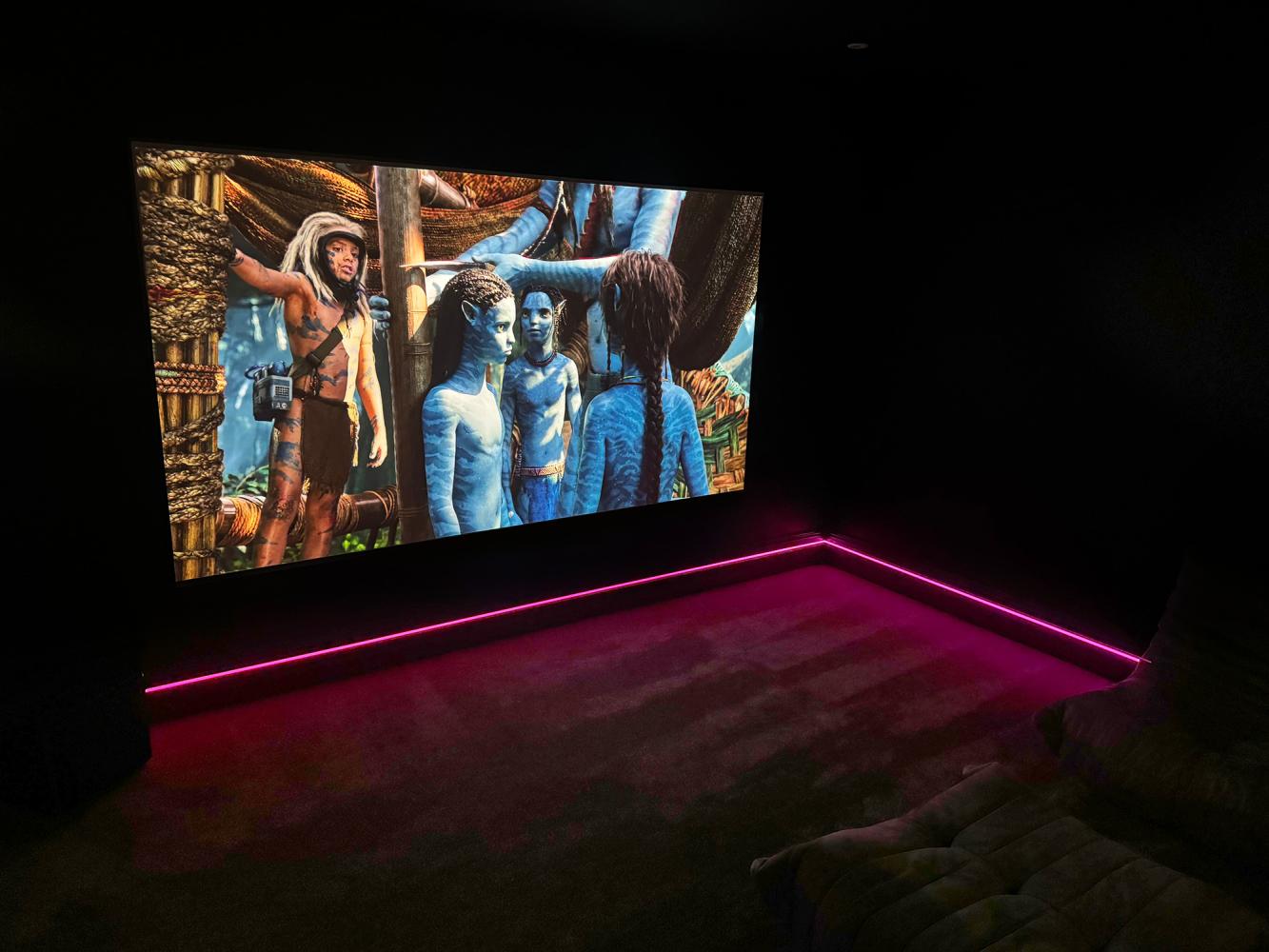 Projector screen coming down in front of TV in living room home theatre
