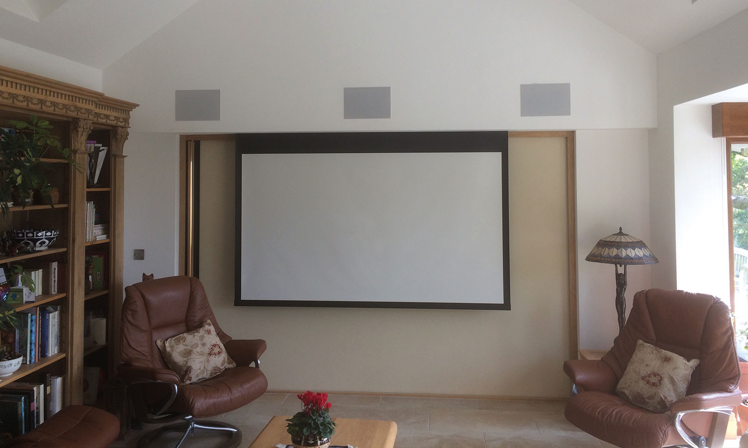 Projector screen infront of bifold doors in garden room
