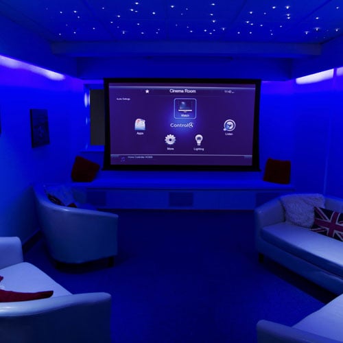 Blue home cinema with screen and tub chairs