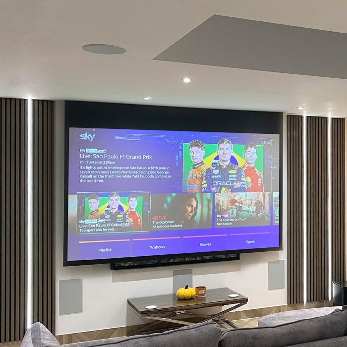Ceiling recessed projector screen in modern room with acoustic wood planes and LED strips