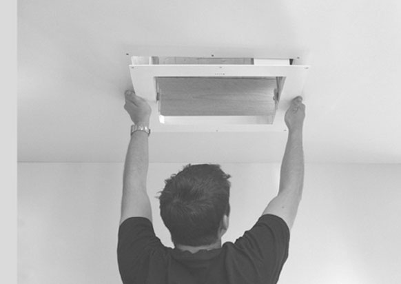 two men lifting projector lift into ceiling